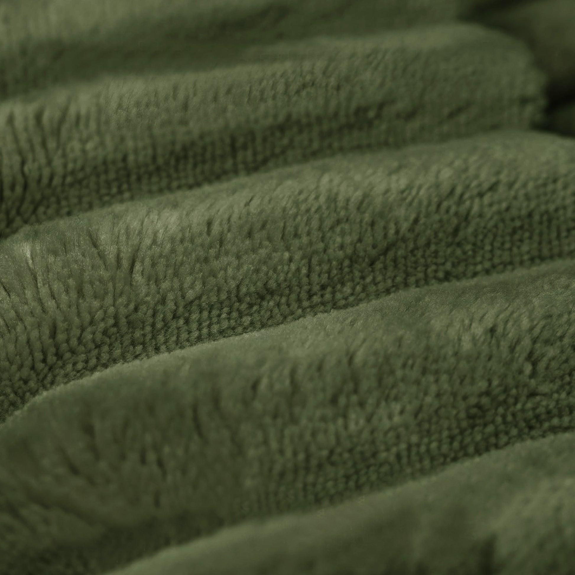 Close-up of the wide-wale green corduroy fabric and channel stitching — Green / 3-Seat