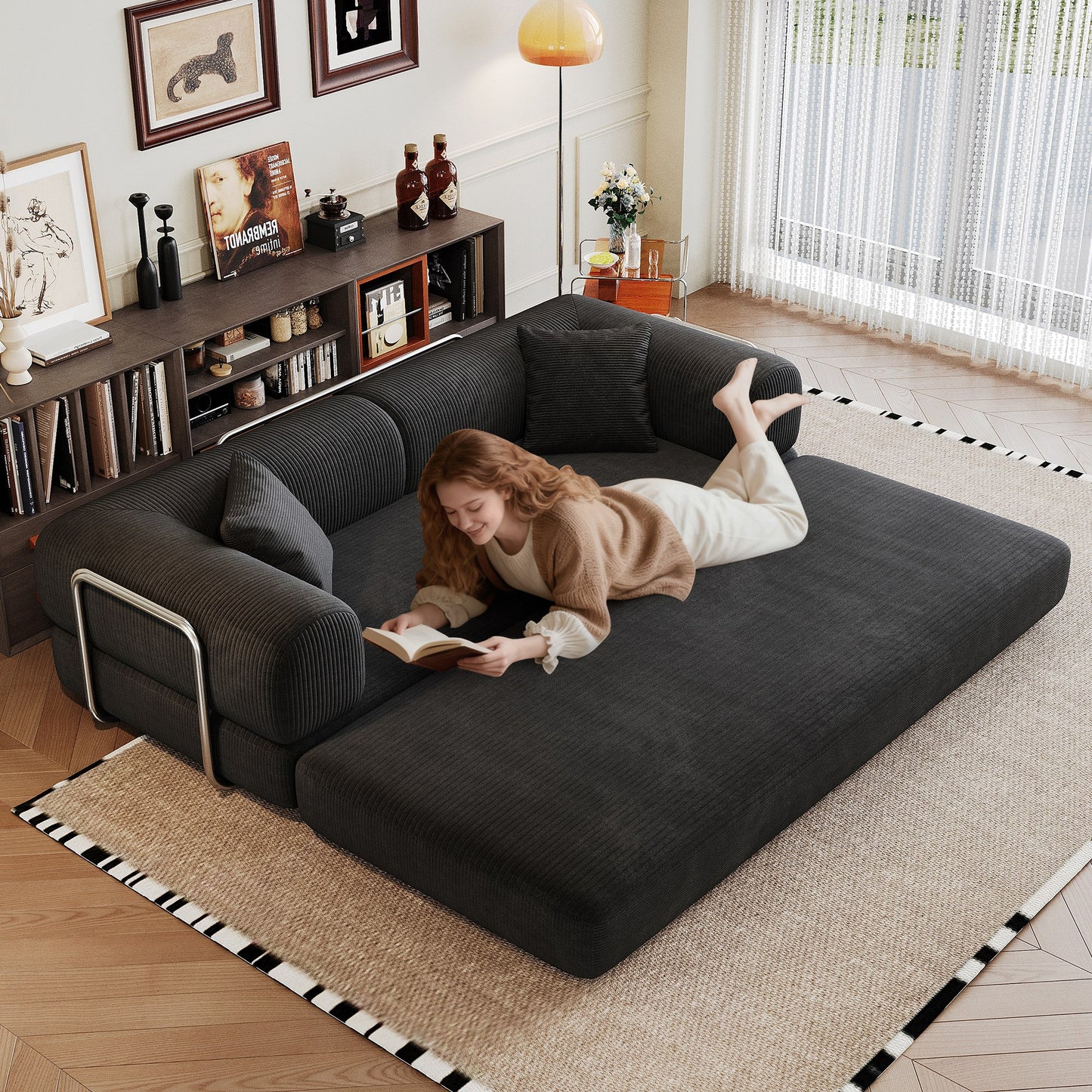 Black corduroy boneless sofa bed unfolded flat into a bed, person lying on it — Black