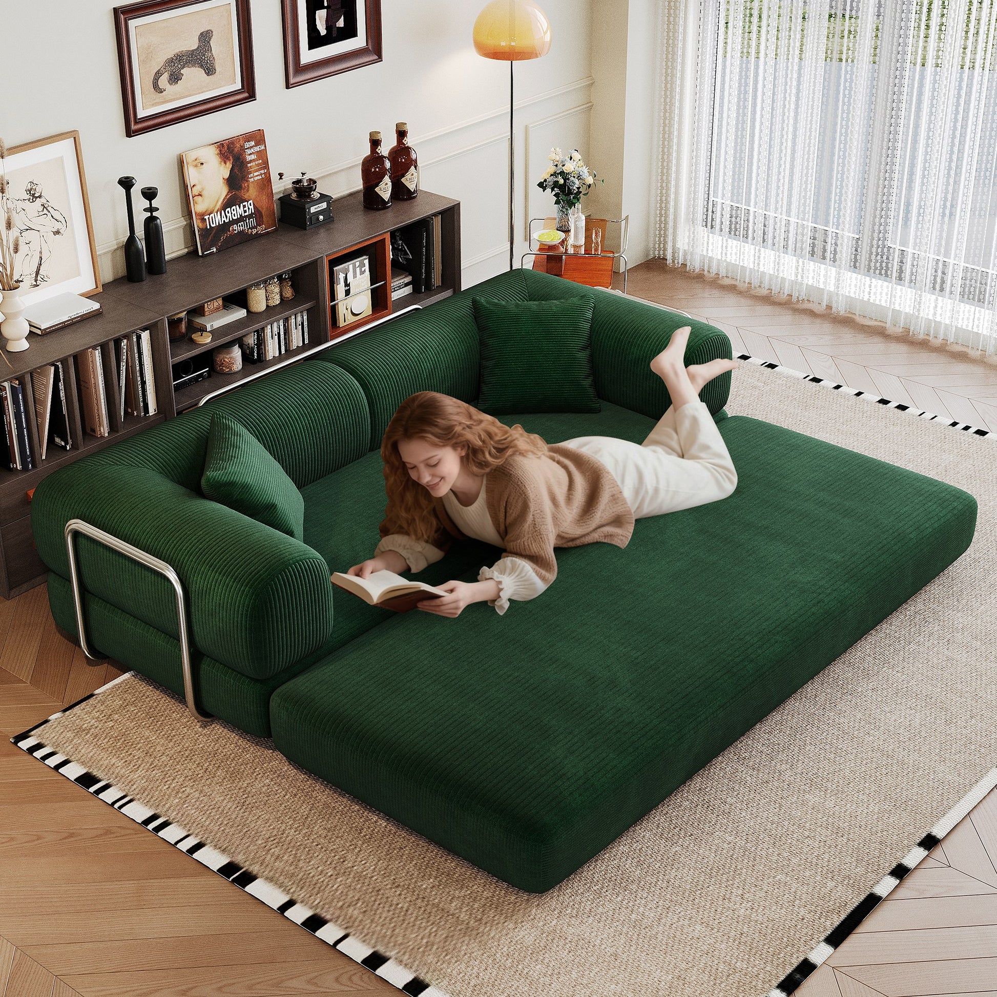 Green corduroy boneless sofa bed unfolded flat into a bed, person lying on it — Green