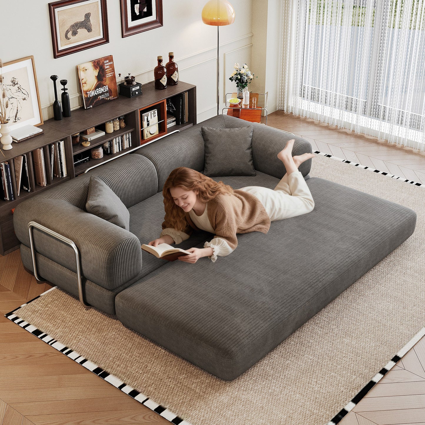 Grey corduroy boneless sofa bed unfolded flat into a bed, person lying on it — Grey
